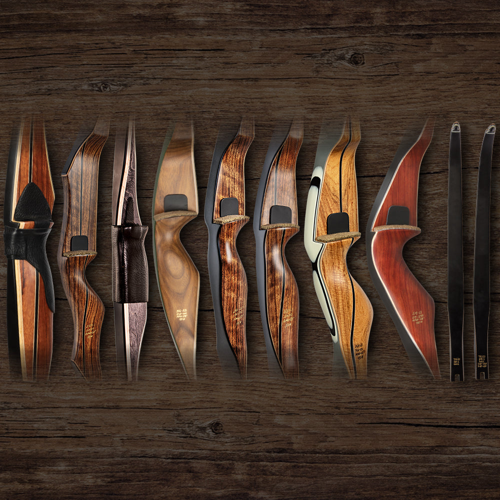 Limited edition Bear Archery traditional bows, both recurve bows and longbows, lined up on a wooden background.
