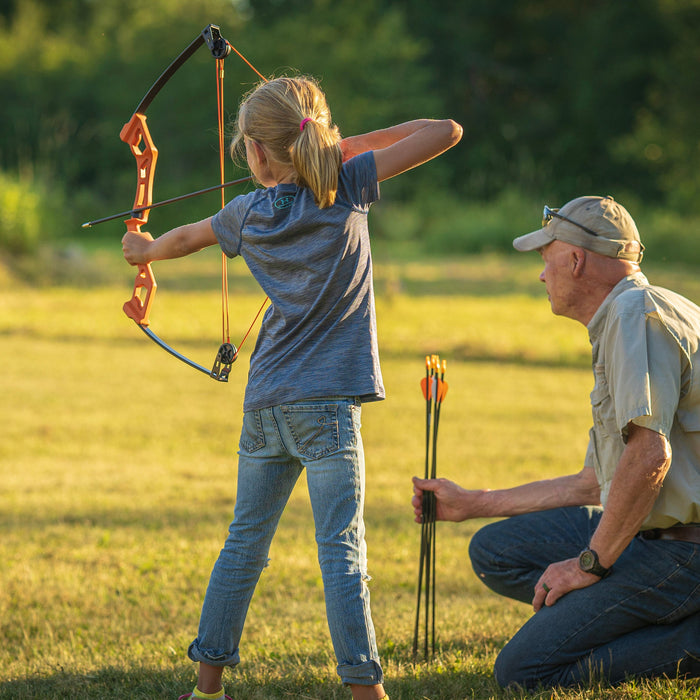 Young girl and her dad shooting a Bear Archery Youth Bow from Bear Archery's Youth Archery category.